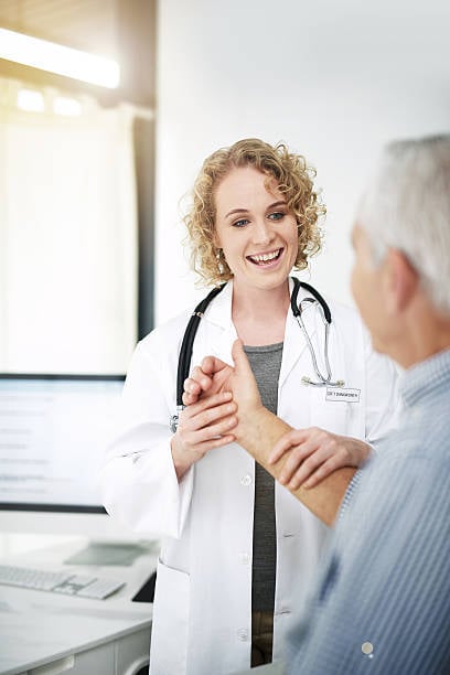 doctor taking vital signs of patient while smiling