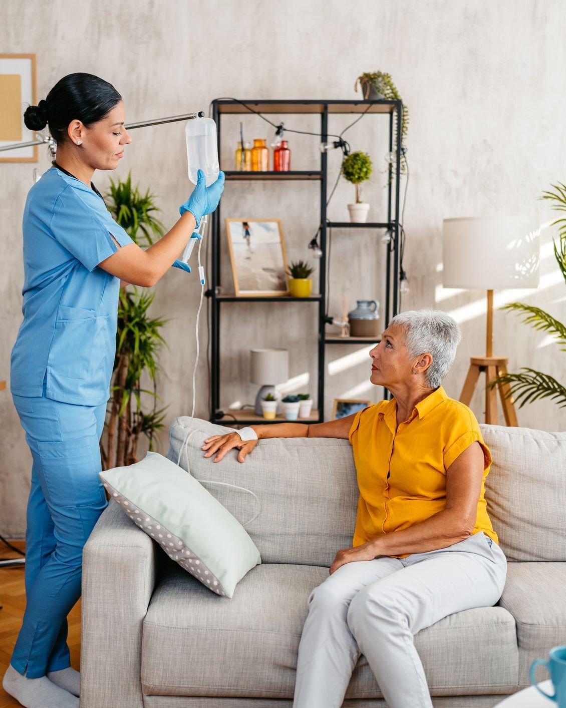 nurse administering intravenous treatment for patient at home