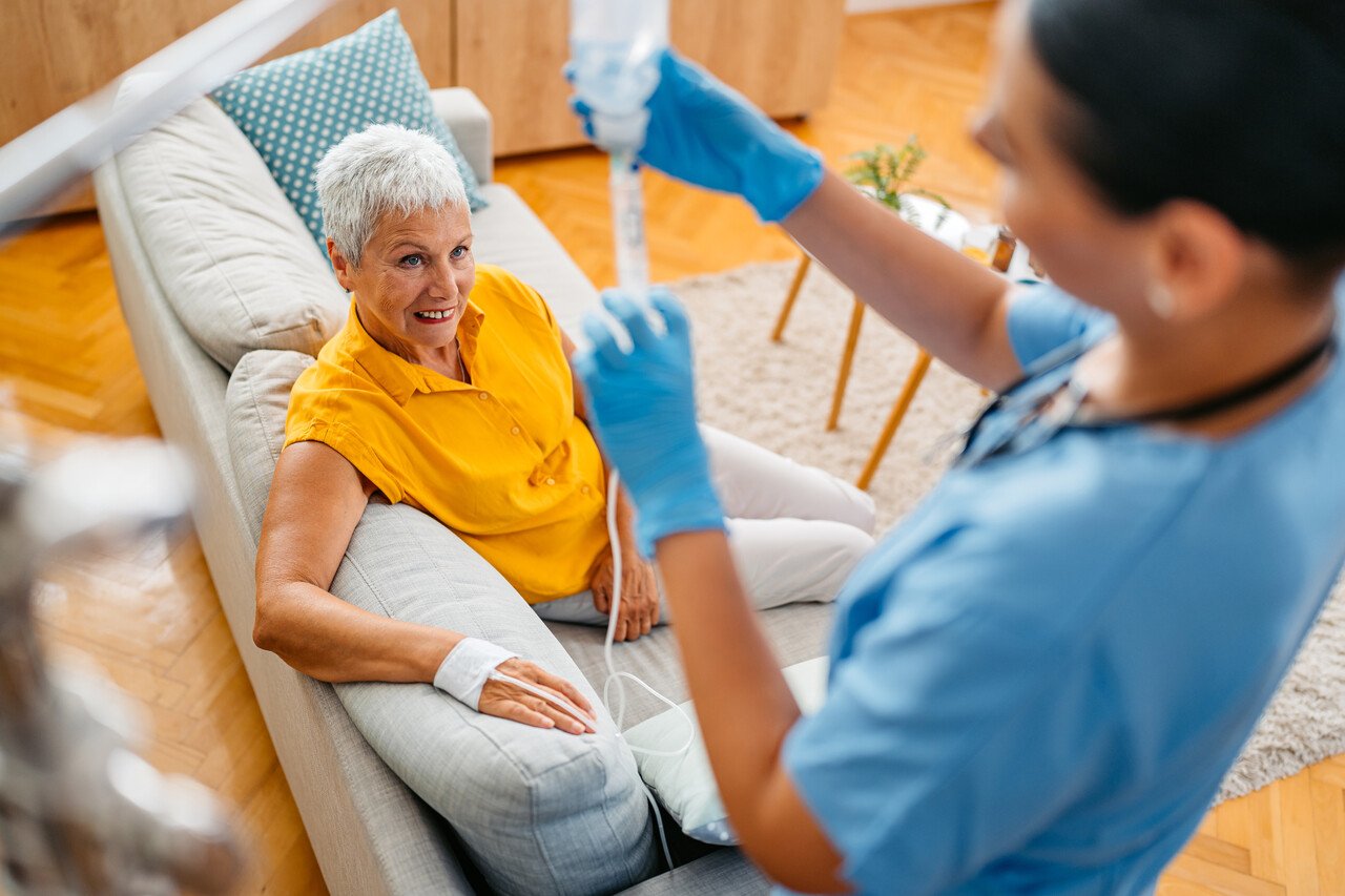 elderly patient smiling at nurse administering IV