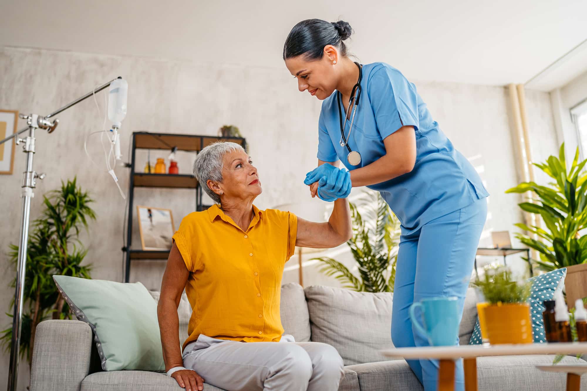 nurses helping patient up off the couch